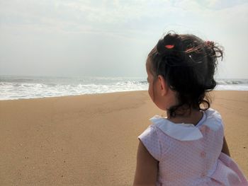 Woman wearing sunglasses on beach against sky