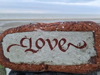 Close-up of text on rock at beach