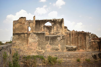 Low angle view of old building against cloudy sky