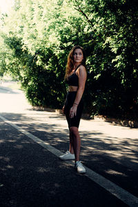 Portrait of young woman standing on road