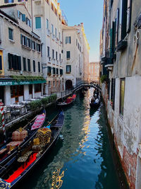 Boats in canal amidst buildings in city