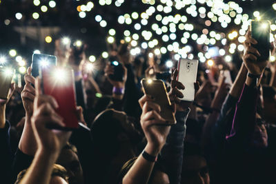 People rising up mobile phone lights