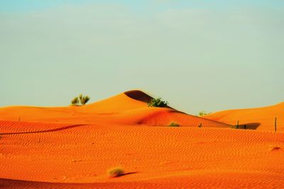 Scenic view of sand dunes against clear sky