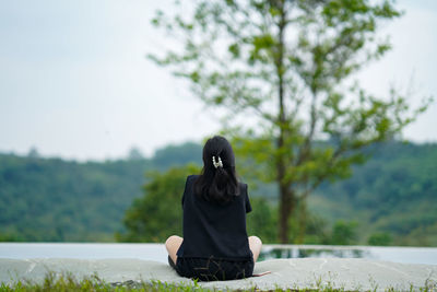 Rear view of woman sitting outdoors