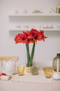 Close-up of red rose in vase on table at home