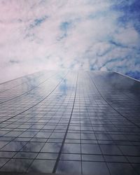 Low angle view of modern building against cloudy sky