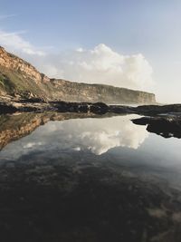 Scenic view of sea and mountains against sky