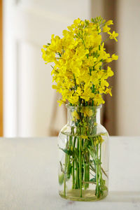 Close-up of yellow flower vase on table at home