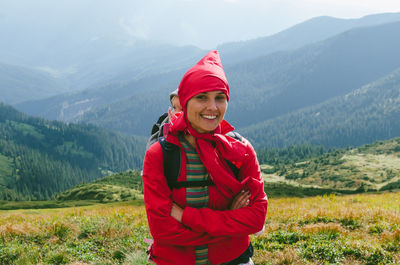 Portrait of smiling mother carrying daughter while standing on mountain