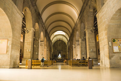 Rear view of people sitting in corridor of building