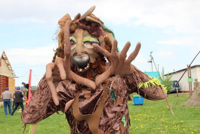 Portrait of person in costume on field against sky