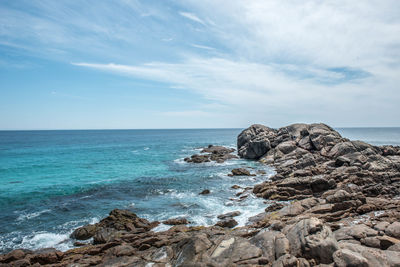 Rock formation on beach against sky