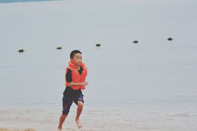 Full length of boy running at beach