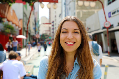 Portrait of smiling young woman in city