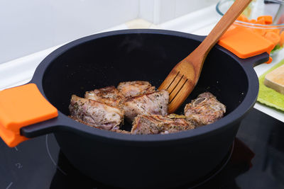 High angle view of meat in cooking pan on table