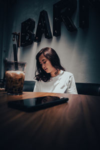 Portrait of a young woman sitting on table