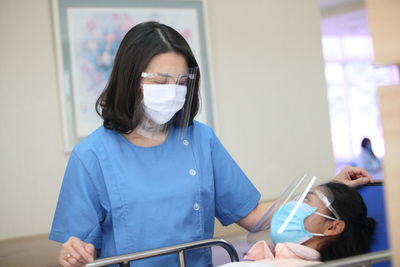 Doctor standing by patient in hospital