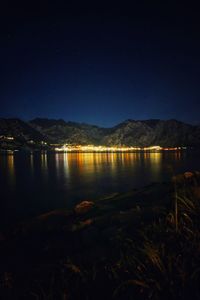 Scenic view of lake against clear sky at night