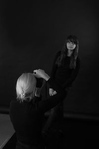 Woman standing against illuminated gray background