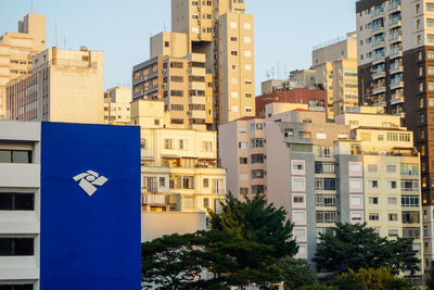 Buildings in city against clear blue sky