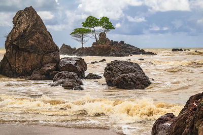 Rocks on beach against sky