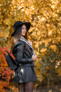 Thoughtful woman wearing hat at park during autumn