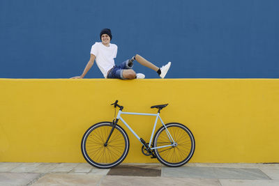 Young male with disability sitting near bike