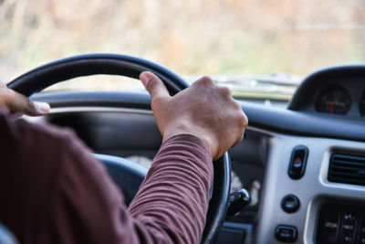 Cropped image of man driving car