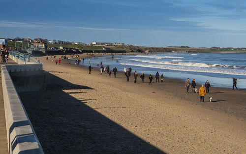 People at beach against sky