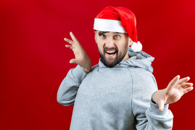 Portrait of young man against red background