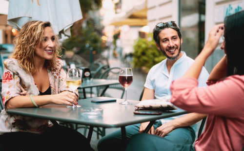 Friends having wine at table in restaurant