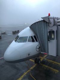 Airplane on airport runway against sky