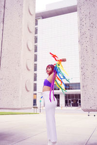 Portrait of woman standing against multi colored wall