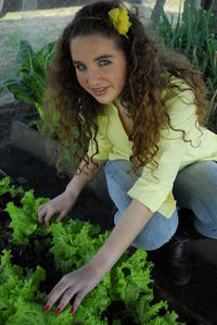 Portrait of smiling woman sitting against plants