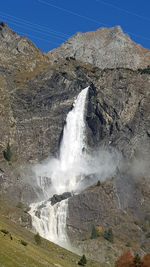 Scenic view of waterfall against sky