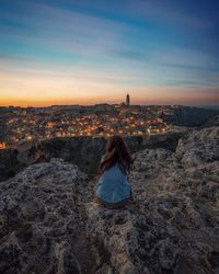 Rear view of woman in city at sunset