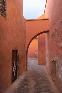 Passage with houses and orange walls in historic medina in marrakech