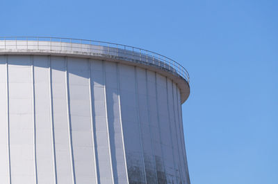 Low angle view of white silo against clear blue sky