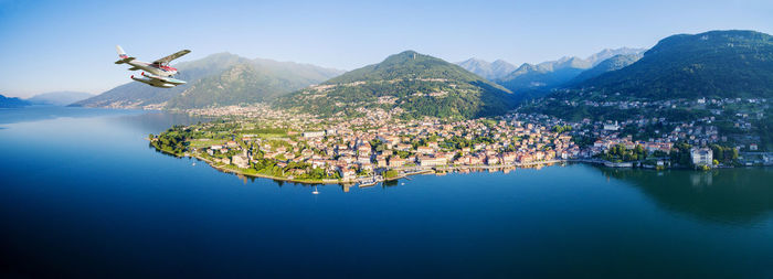 Airplane over lake towards town