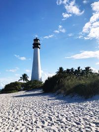 Lighthouse amidst trees against sky