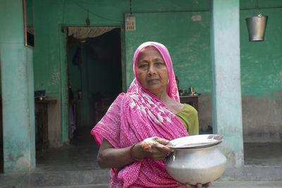 Portrait of indian woman standing outside her house 