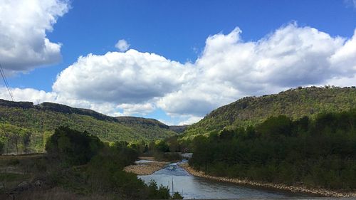 Scenic view of river against cloudy sky