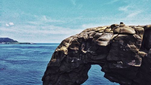 Scenic view of rock and sea against sky