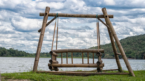 View of swing in playground against cloudy sky