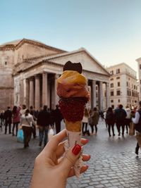 Midsection of woman holding ice cream against sky