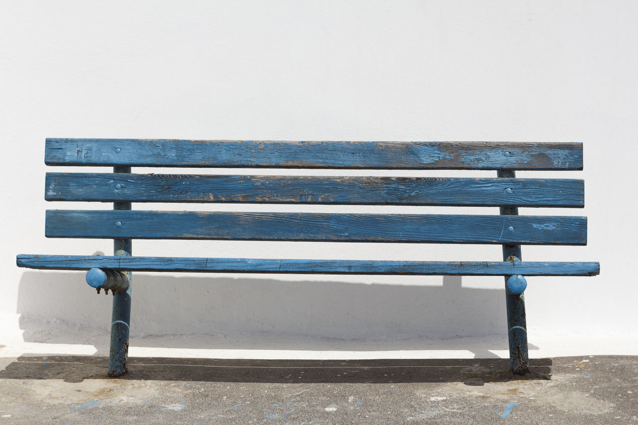 EMPTY BENCH ON TABLE AGAINST WALL