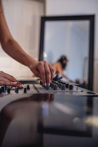 Cropped hand of woman playing sound mixer at home