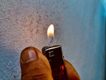 Close-up of hand holding lit candle