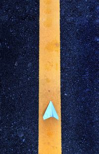 Directly above shot of paper airplane on road