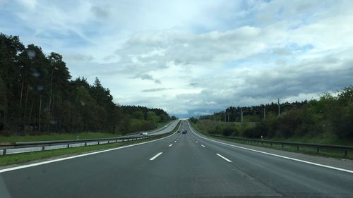 Road amidst trees against sky